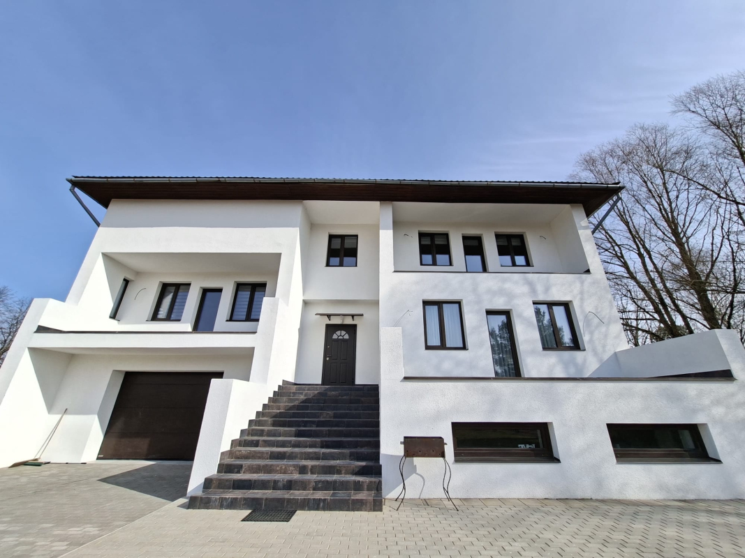 Viesu mājas Magnolija baltā fasāde ar melniem akcentiem un kāpnēm